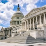 Bright mid-day view of the traditional neoclassical architecture of the Capitol Building’s dome, columns, and steps in Washington DC, USA
